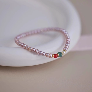 Detailed macro shot of freshwater pearl bracelet with colored agate beads and gold spacers