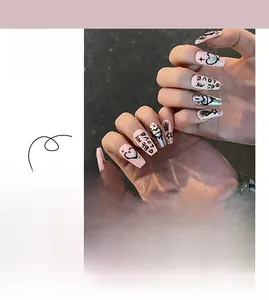 Detail of pink and black graffiti press-on nails with silver hearts and star patterns