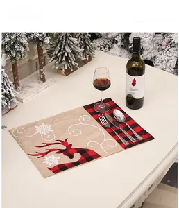 Détail du set de table de Noël avec broderie élan et texture en lin à carreaux rouges