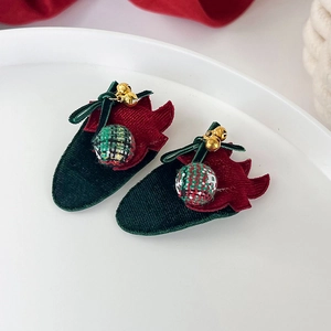 Détail de barrettes fraises avec texture velours, boules tissées et petites cloches dorées