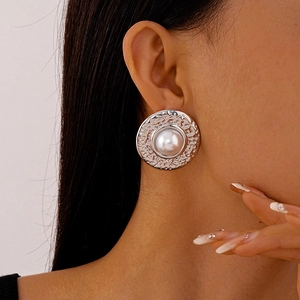Macro view of vintage silver textured round earrings with a large white pearl center