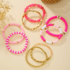 Stack of pink and white Heishi bead bracelets with gold metallic and faceted glass details