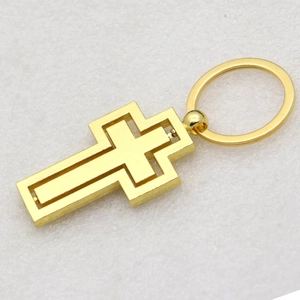 Macro shot of a golden double-layered rotating cross pendant for car keychains