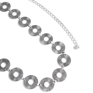 Macro detail of vintage punk metal waist chain with sunburst engraved hollow circular links