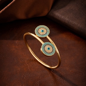 Golden open bangle with evil eye design and blue zircon inlays on textured leather