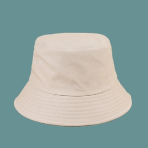 Detail of cream bucket hat with parallel stitching on brim against blue backdrop