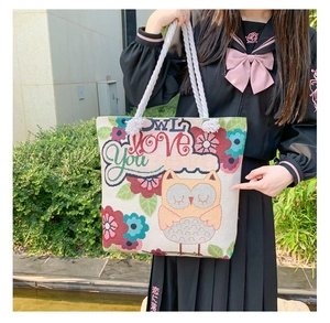 Detail of owl embroidery and floral pattern on a large canvas tote bag with cotton ropes