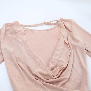 Close-up of nude pink backless jumpsuit with elegant draped pleats and shimmery crepe texture