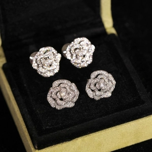 Gros plan détaillé des boucles d'oreilles camélia argentées avec des strass étincelants