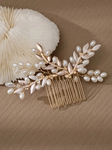Detalle del peine de novia con ramas de metal dorado, perlas blancas y hojas finas