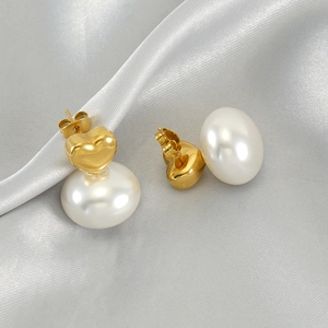Elegant gold heart pearl drop earrings for women on a silver silk fabric background