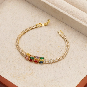Dettaglio del bracciale tennis dorato con doppia fila di diamanti e pietre colorate
