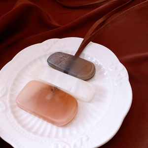 Detailed view of three marble-patterned acrylic pendants on a white embossed ceramic plate