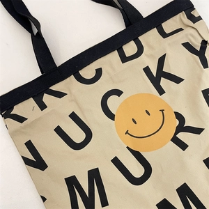 Close-up of durable canvas fabric with yellow smiley face and Lucky text print