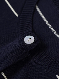 Macro detail of high-quality navy striped knit fabric with a pearl button and ribbing