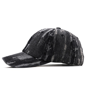 Detail shot of distressed charcoal denim baseball cap showing retro frayed hole texture
