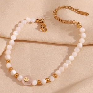 Detail of beaded bracelet with white pearls, gold spacers and pink hexagonal stone