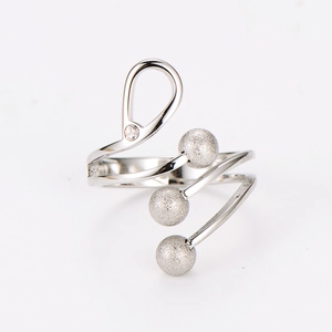 Detail of spiral stainless steel ring featuring frosted beads and a sparkling zircon