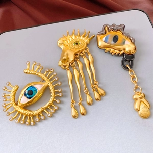 Detailed macro shot of vintage surrealist eye brooches with rhinestones and gold finish