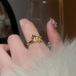 Detail of elegant gold meteor star ring with sparkling zircons worn on a finger