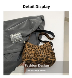 Close-up of leopard print faux fur hobo bag with black leather strap and golden hardware