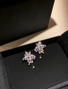 Detailed macro view of silver star earrings with brilliant cubic zirconia and tassels