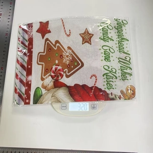 Close-up of Christmas placemat with gingerbread man prints and festive wishes