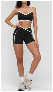 Detail of V-neck sports bra and high-waisted gym shorts with white contrast trim