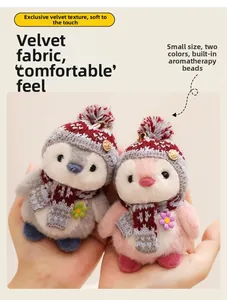 Close-up of pink and grey plush penguin dolls with scented particles and knit scarfs