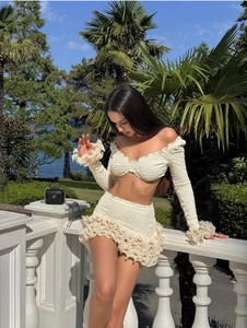 Detail of cream puff sleeve crop top and mini skirt with ruffled edges and seersucker texture