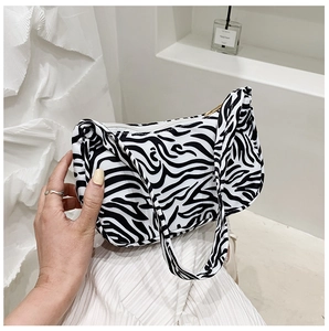 Close-up of zebra print underarm bag with black and white texture and gold zipper detail