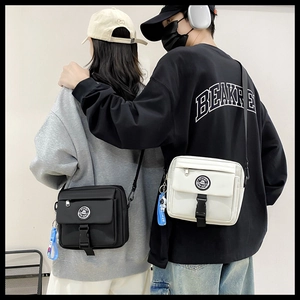Detail of black and white nylon crossbody bags featuring astronaut charms and logo patches