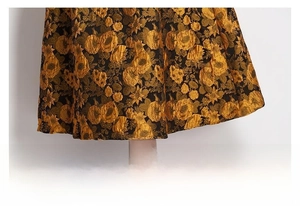 Detail view of heavy jacquard fabric with vintage floral pattern on a loose skirt hem