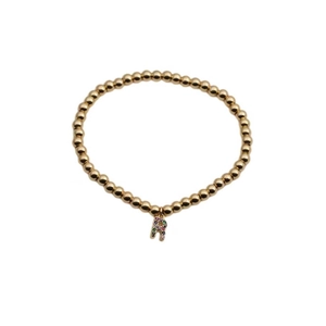 Detail of gold beaded bracelet featuring a colorful rhinestone letter R pendant charm