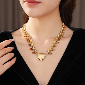Gros plan d'un collier vintage en feuilles d'or avec cristaux d'ambre sur mannequin