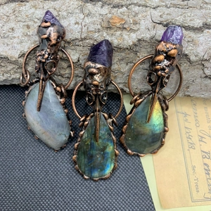 Vue détaillée du pendentif crâne de corbeau avec pierre améthyste et labradorite