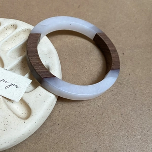 Detailed shot of resin and wood patchwork bangle on a textured beige display