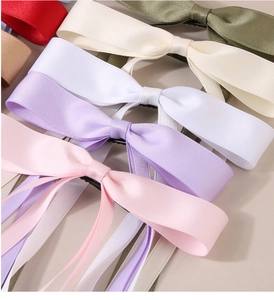 Close-up of assorted colorful satin ribbon bow hair clips in various elegant shades