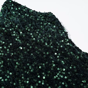 Macro shot of dark green sequin fabric on velvet material for elegant evening gowns