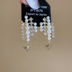 Detail view of 925 silver fringe earrings with luxury star zircon and white pearls
