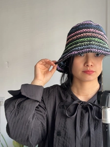 Detail of handmade crochet bucket hat with colorful stripes and woven texture