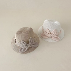 Close-up of khaki and cream straw hats with cat ears and bow details for babies