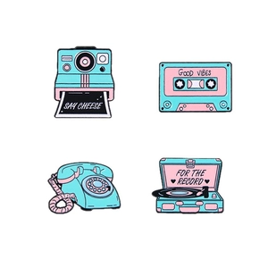 Set of four retro enamel pins featuring vintage camera, cassette, phone, and record player