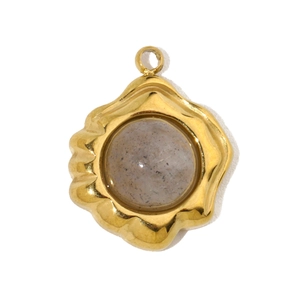 Detailed close-up of a wavy gold bezel pendant with an inlaid grey translucent stone