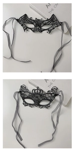 Detail of black lace masquerade masks with bat and crown designs on white background