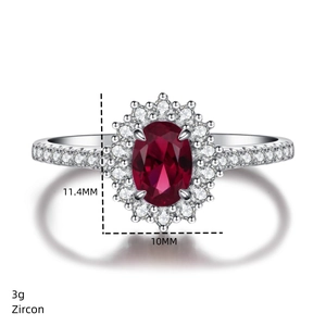 Macro shot of silver ring with oval red zircon and diamond halo showing dimensions