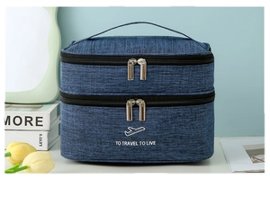 Close-up of blue dual-layer toiletry bag with handle and travel slogan print