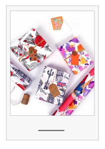 Close-up of colorful gift wrapping paper featuring geometric and London patterns with twine