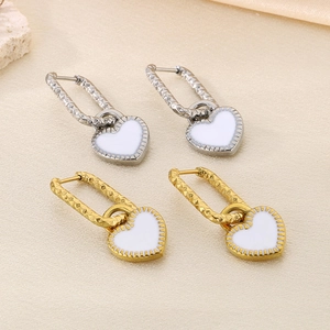 Boucles d'oreilles cœur modernes en or et argent sur fond en soie élégante