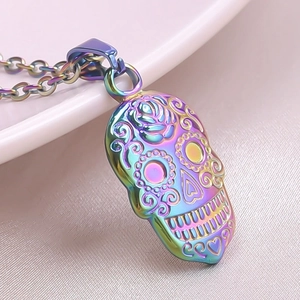 Macro shot of colorful iridescent sugar skull necklace pendant on pink silk